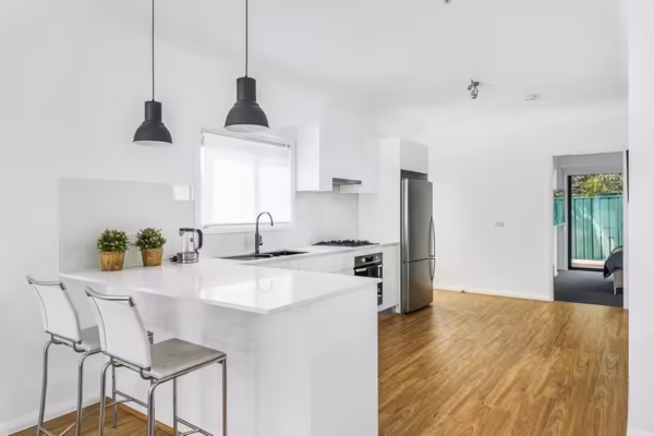 granny-flat-sydney-bungalow-one-bedroom-carpet-kitchen-design-breakfast-bar-quantum-quartz-benchtop-pendant-lights-timber-laminate-floor